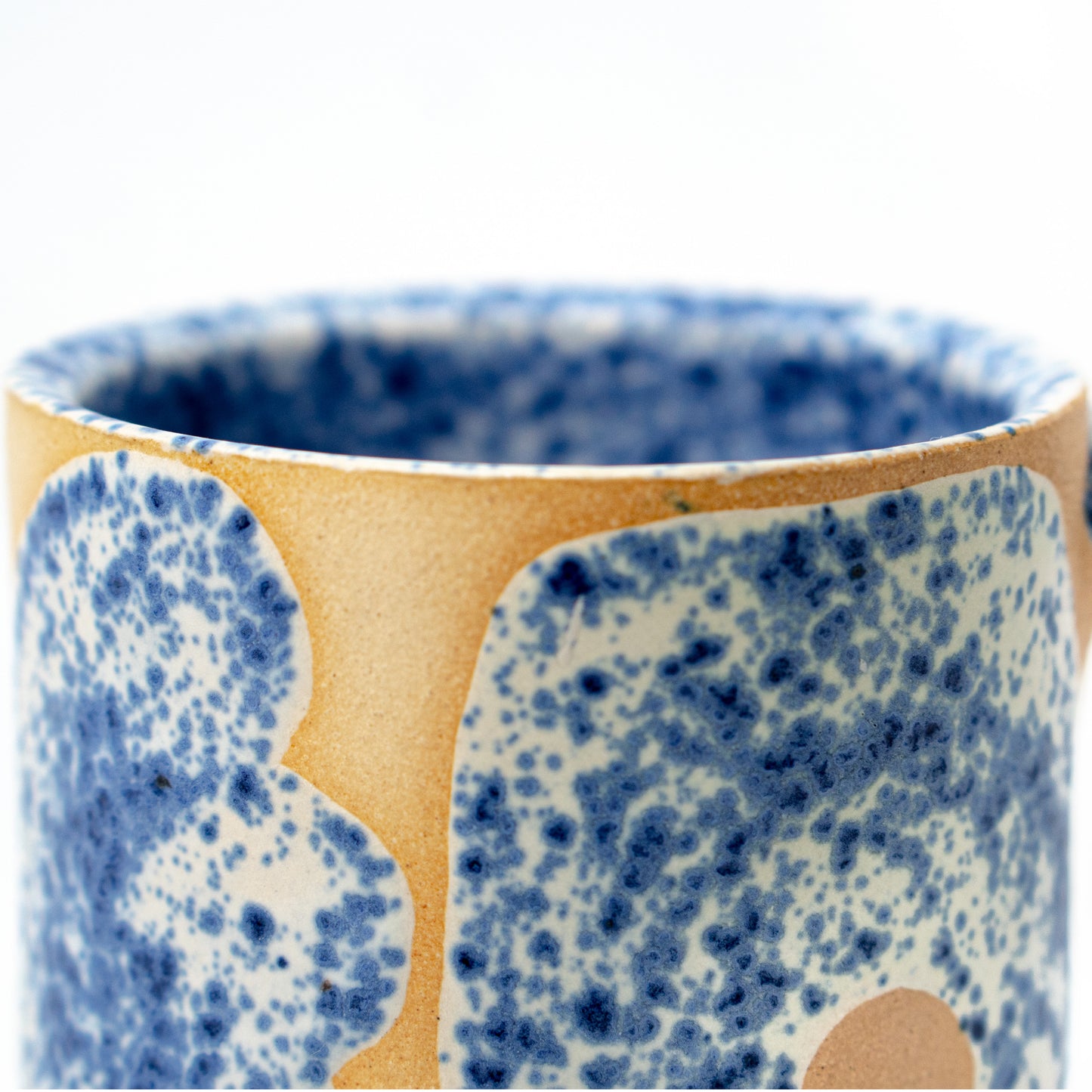 close up cream and blue speckled ceramic mug by a hill studio