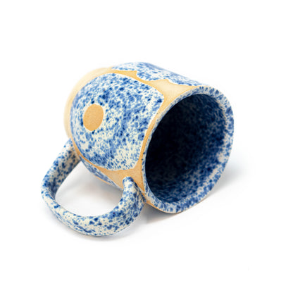 side shot of cream and blue speckled ceramic mug by a hill studio