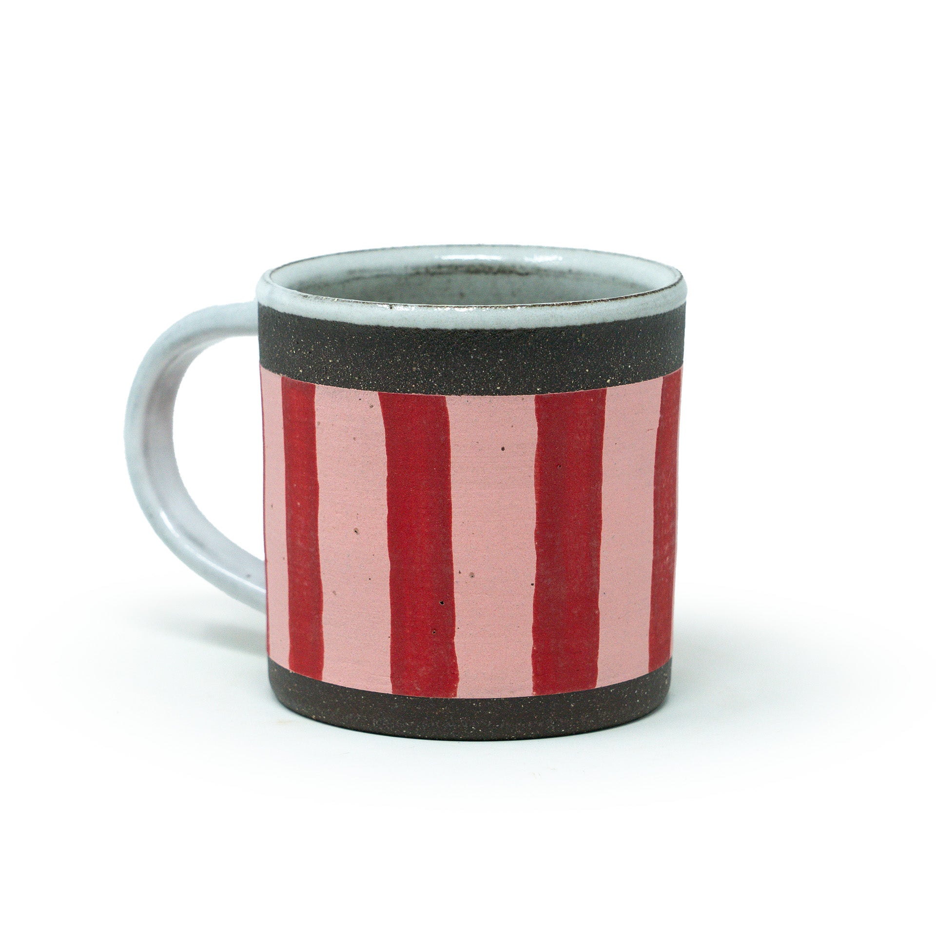 Ceramic mug with red and pink striped design on a white background