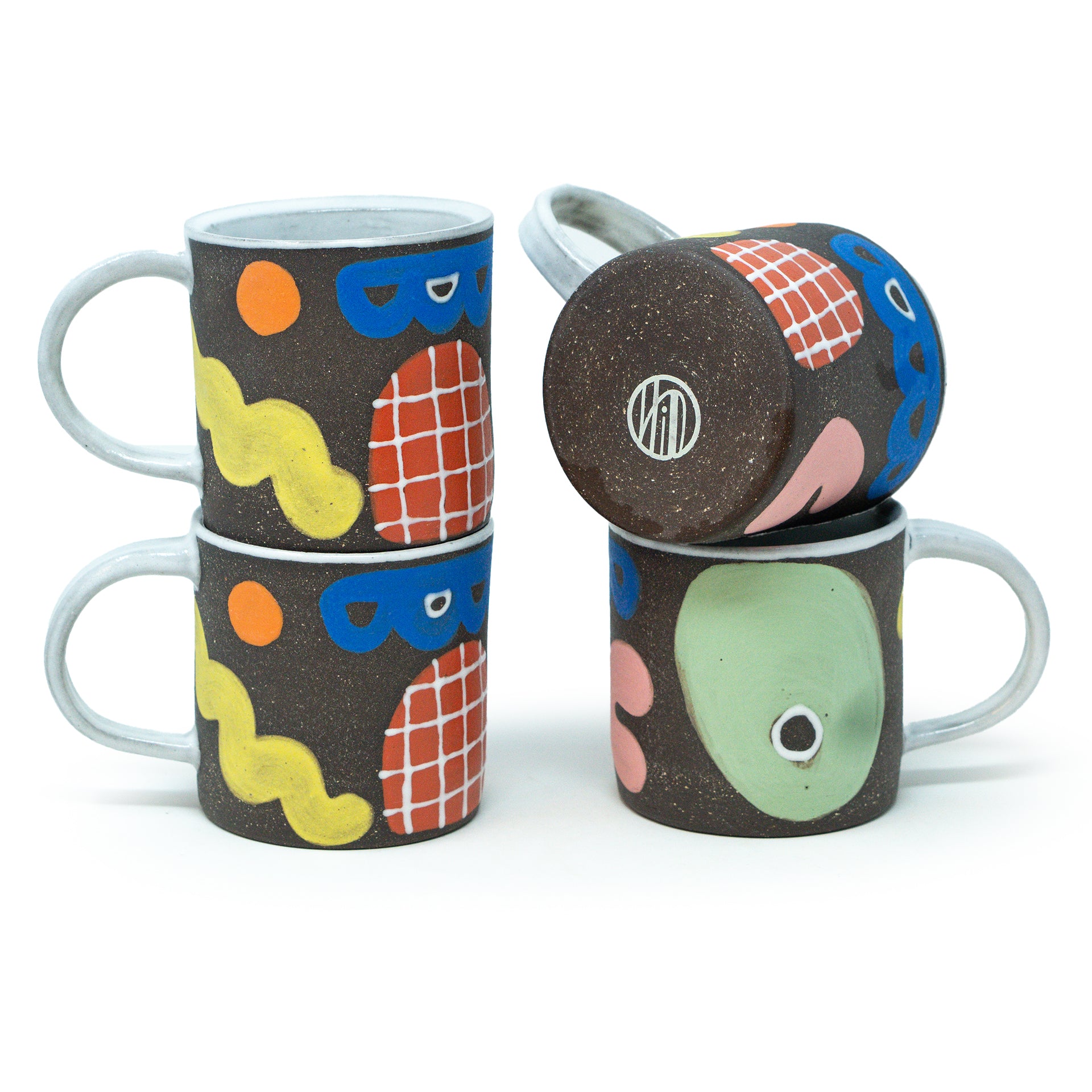 Set of colorful ceramic mugs with abstract designs on a white background