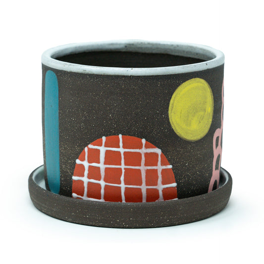 Ceramic planter with colorful abstract designs on a white background